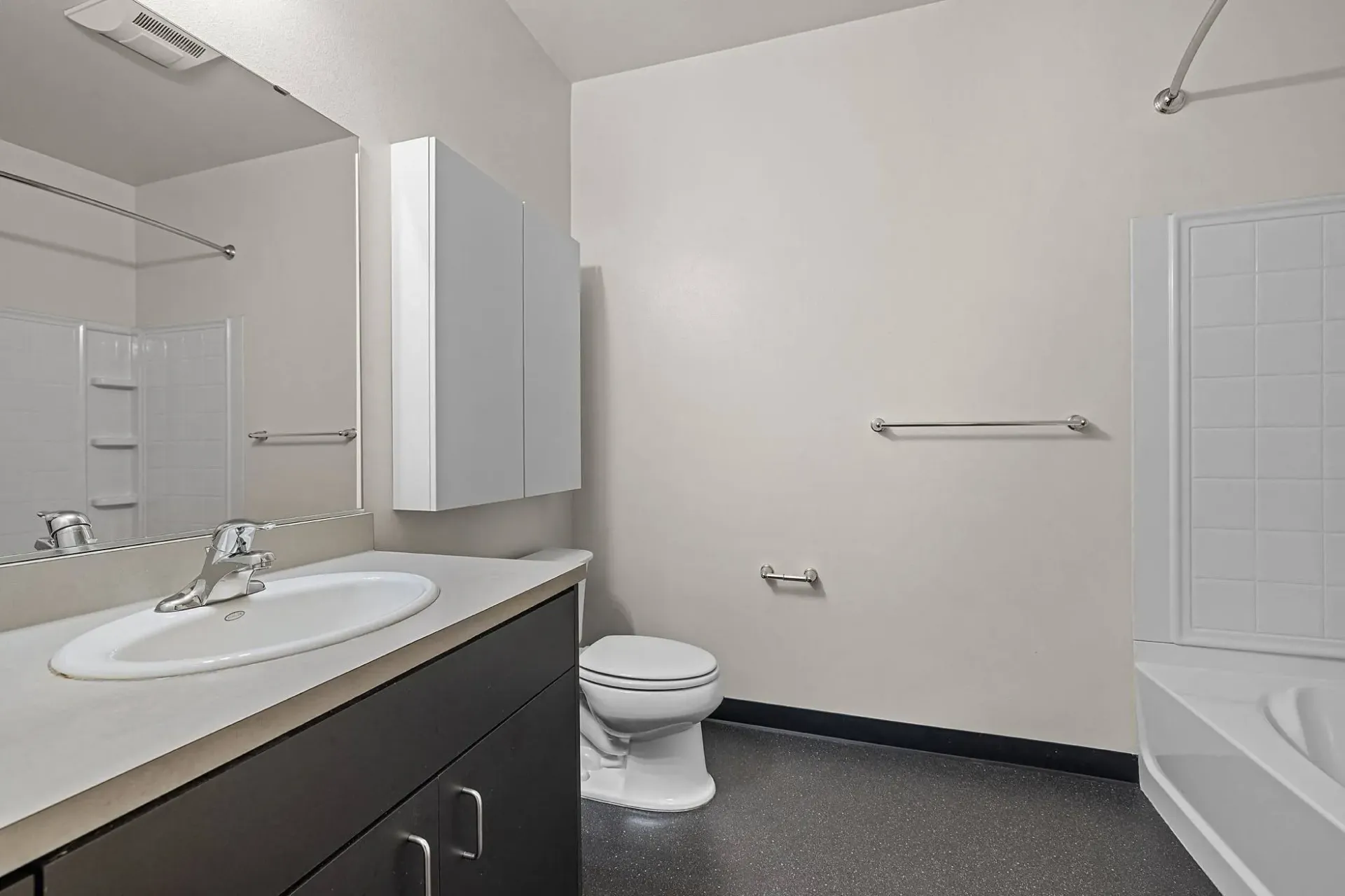 Modern bathroom with vanity, sink, toilet, and bathtub.