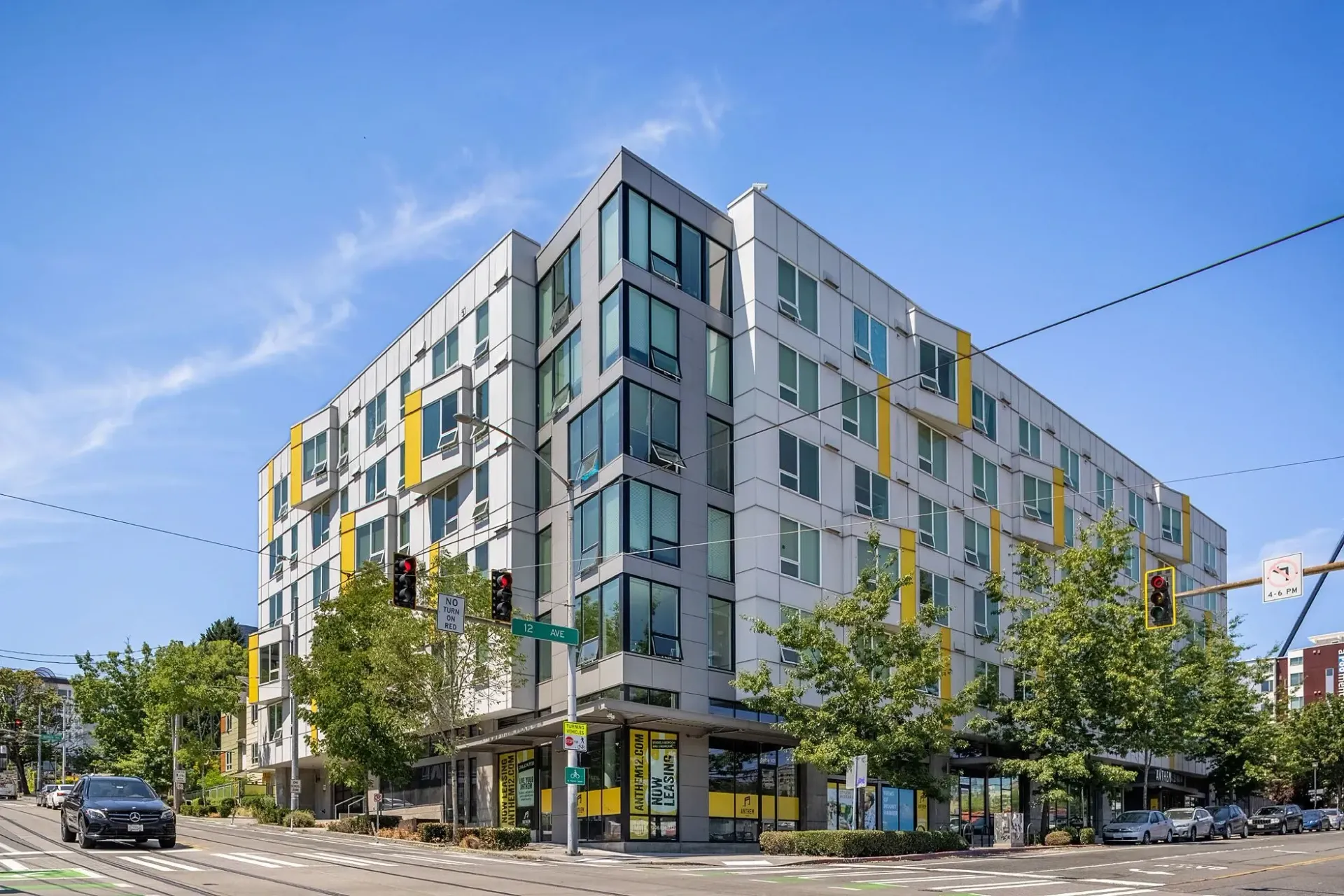 Modern apartment building with yellow accents on a sunny day.