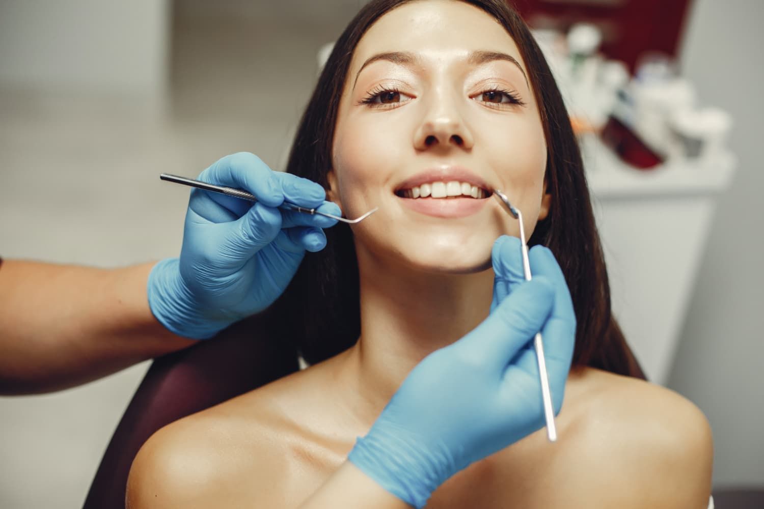 Dentist adjusting braces on a smiling patient in a clinic