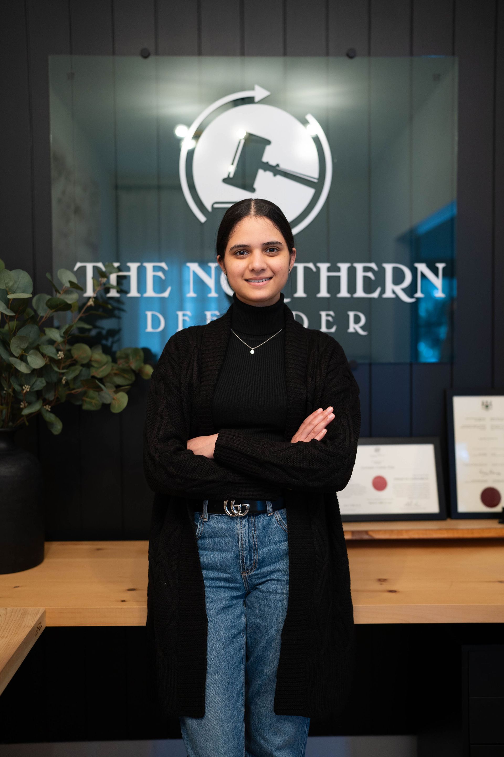 Woman standing with arms crossed in front of The Northern Doughter sign and awards display