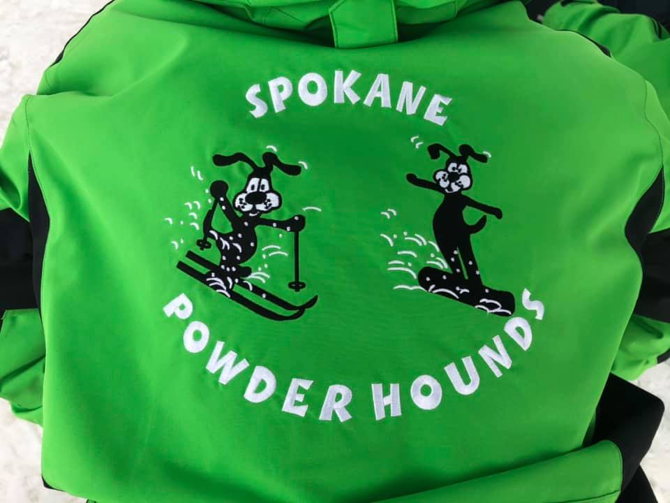 Green Spokane Powderhound hoodie with two cartoon skiers and white lettering
