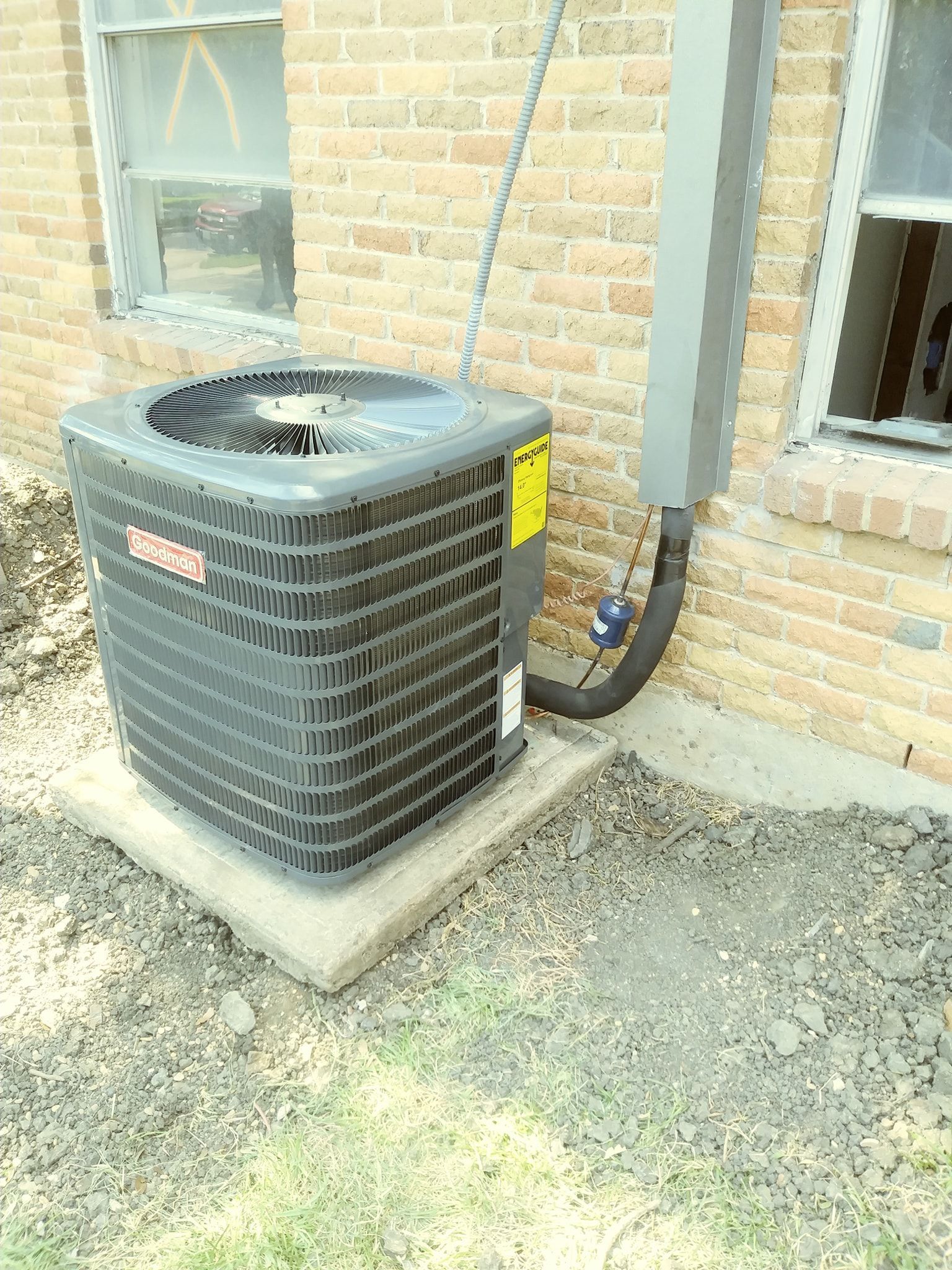 an air conditioner is sitting on the side of a brick building .