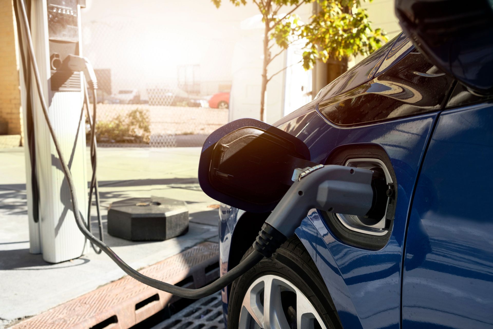 An electric vehicle plugged into a charging station, highlighting EV charger installation in Moon To