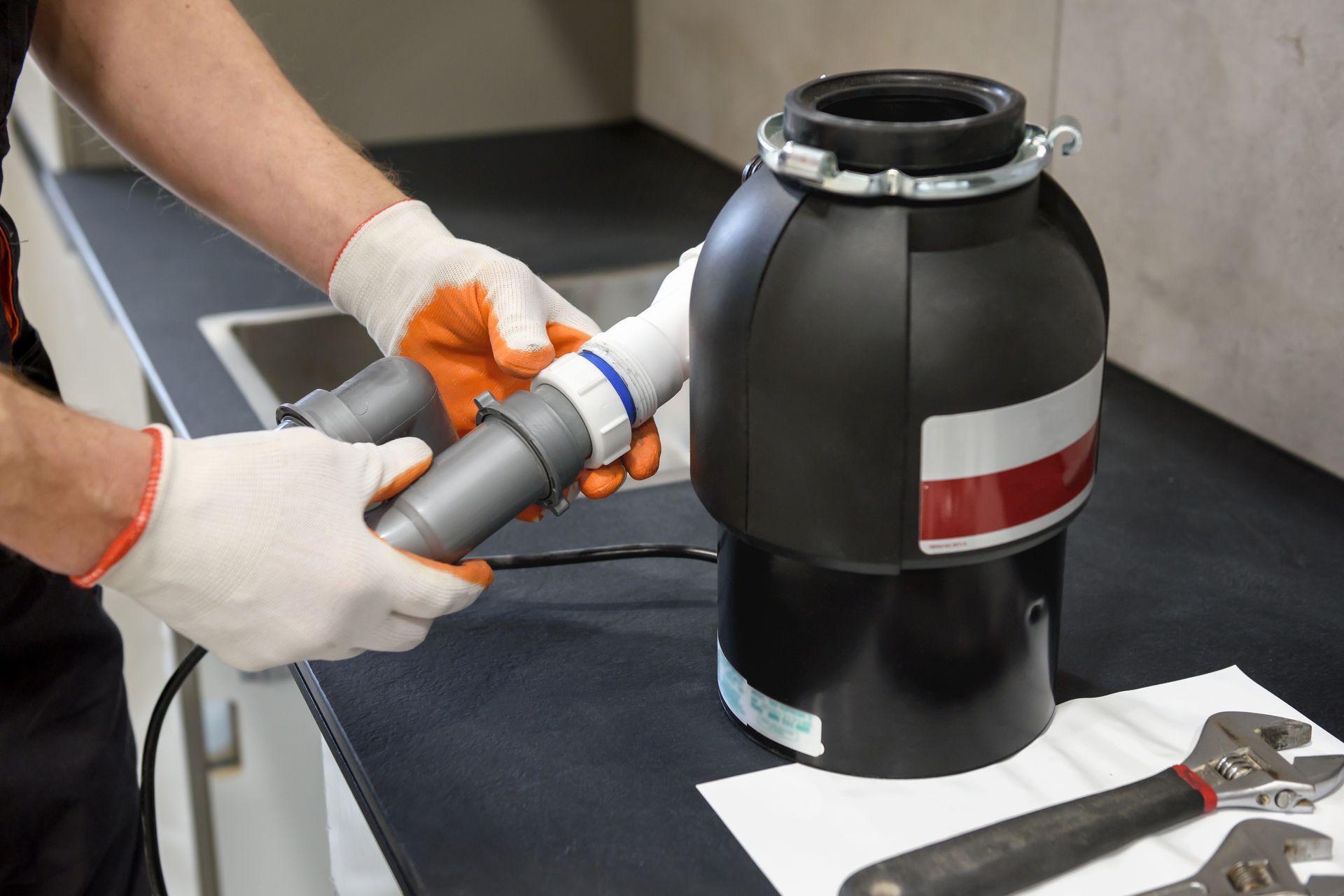 Technician repairing a kitchen garbage disposal system, providing trusted Plumbing services in Copley for local homeowners.