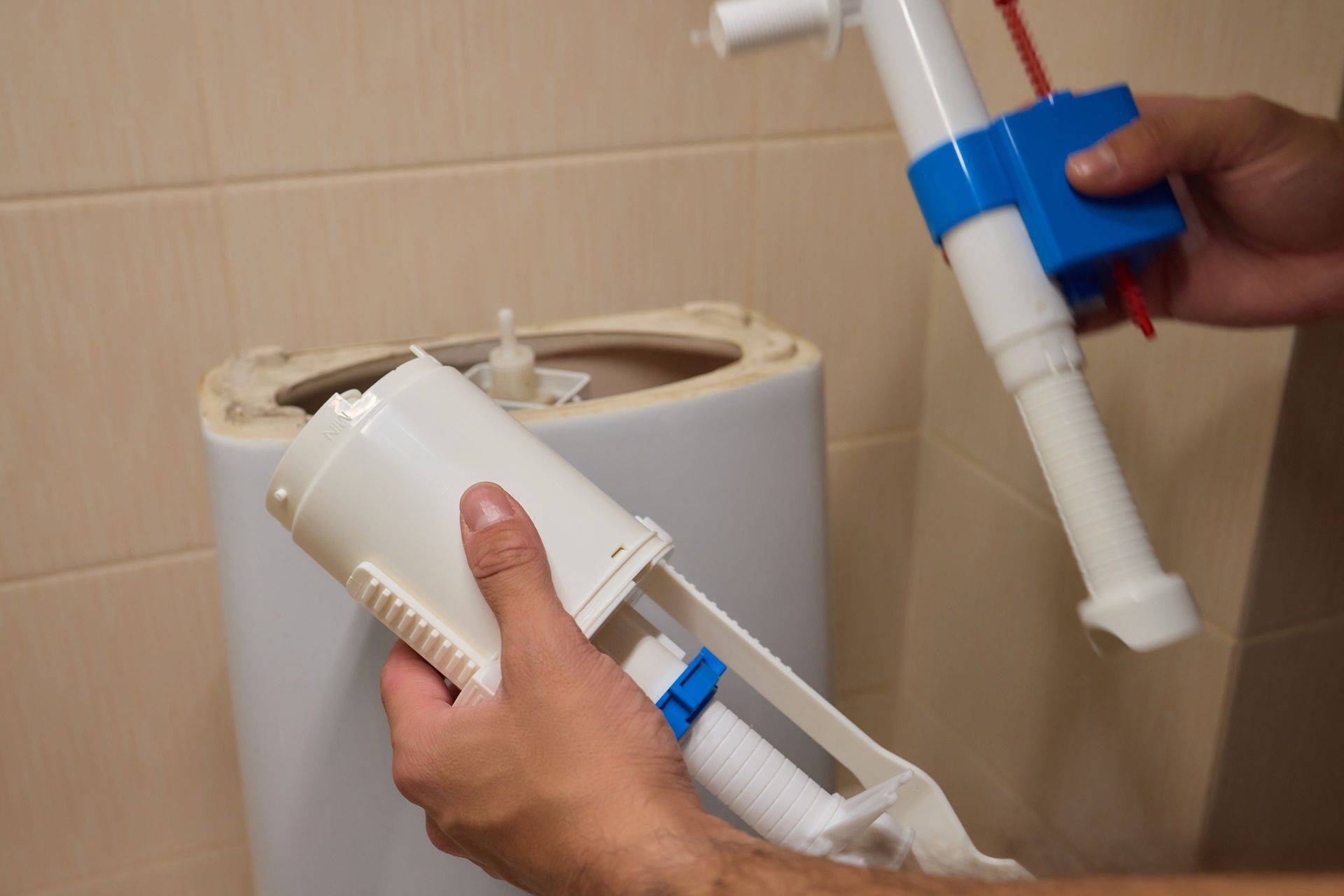 Technician repairing a bathroom toilet, providing reliable Plumbing services in Copley for residential homes.