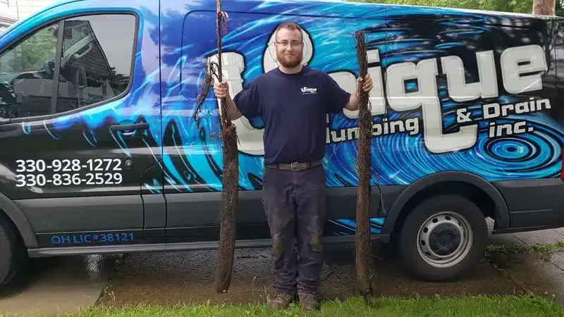Technician standing in front of Unique Plumbing & Drain Inc. service van providing reliable Plumbing Repair Youngstown solutions.