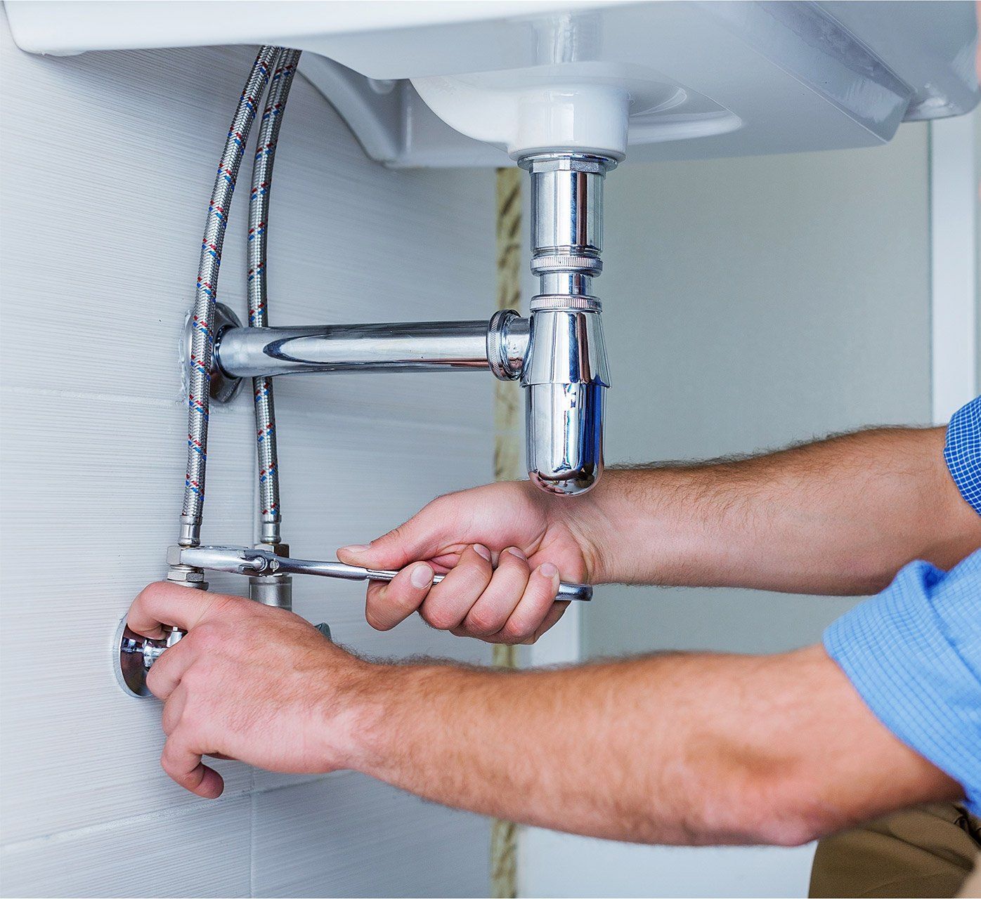 Close-up of sink plumbing and pipes underneath cabinet serviced by expert Plumber In Cuyahoga Falls professionals.