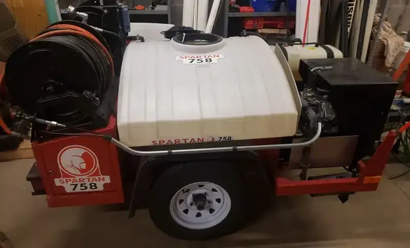 Service trailer with hose equipment in a garage used for professional Drain services in Canton jobs.