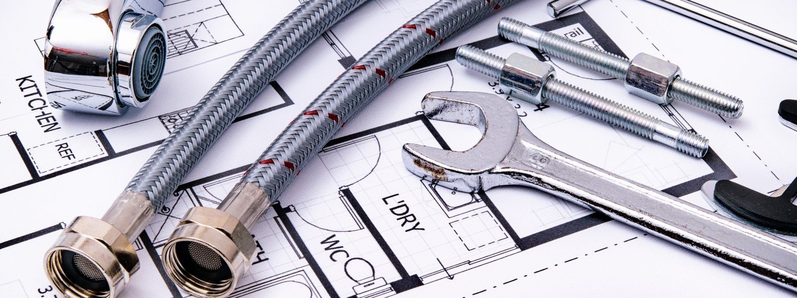 Plumbing services in Copley, close-up of plumber tools, and a faucet on a home blueprint