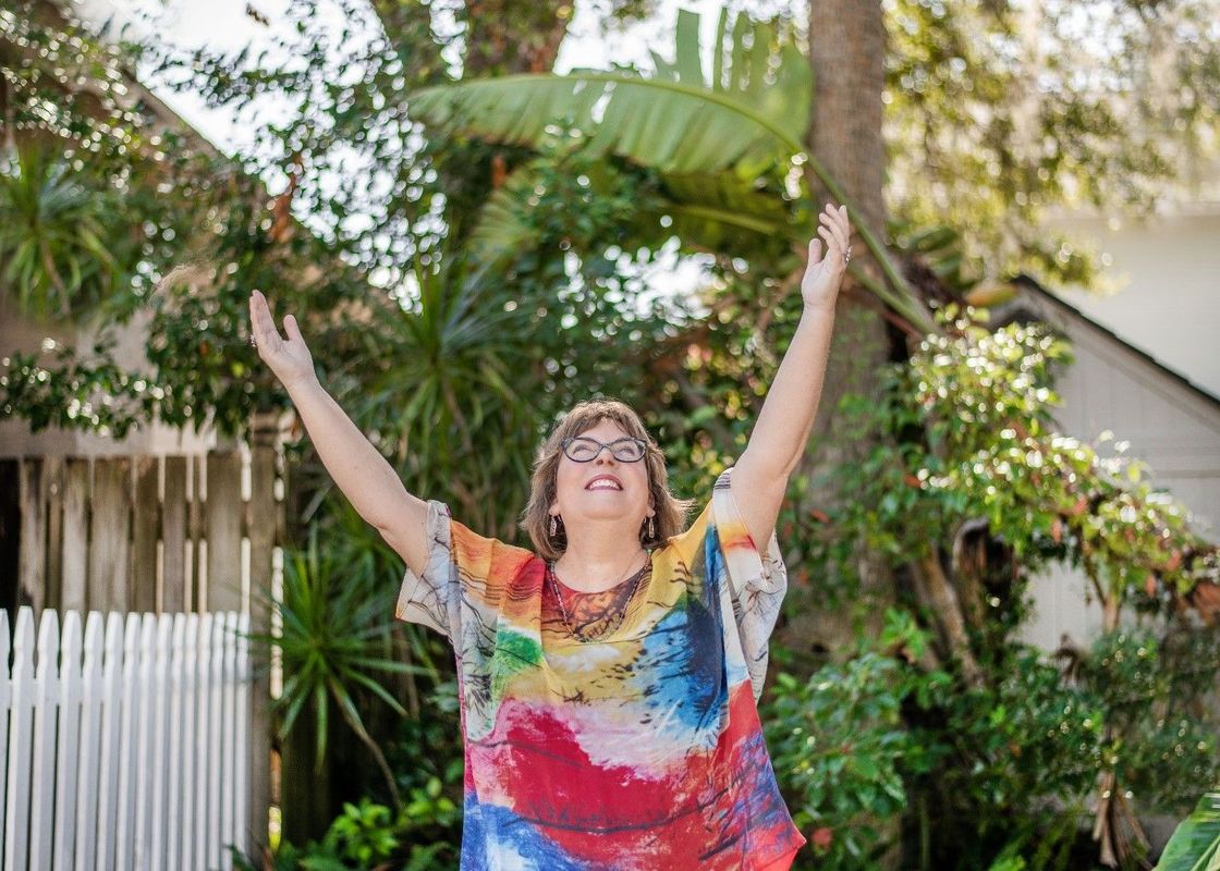 Missy Barnes with arms raised in a garden