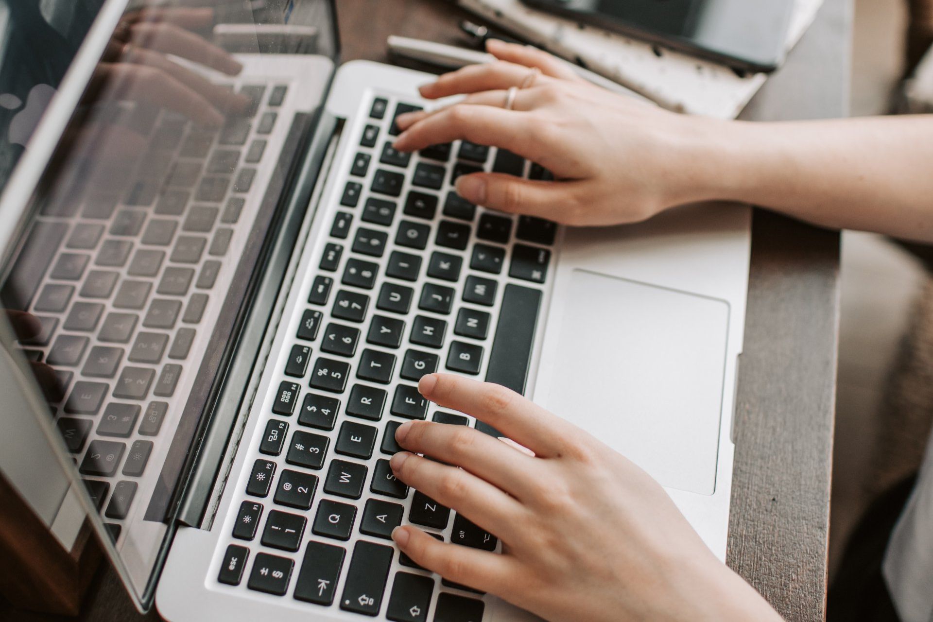 A Person Typing on a Laptop at Overseas Filipino Workers An image of person typing on a laptop at Overseas Filipino Workers