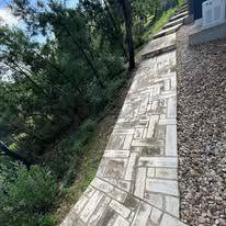 A brick walkway leading to a house in the woods.
