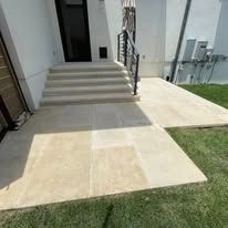 A concrete walkway with stairs leading up to a house.