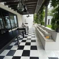 A black and white checkered floor with a table and benches on a porch.