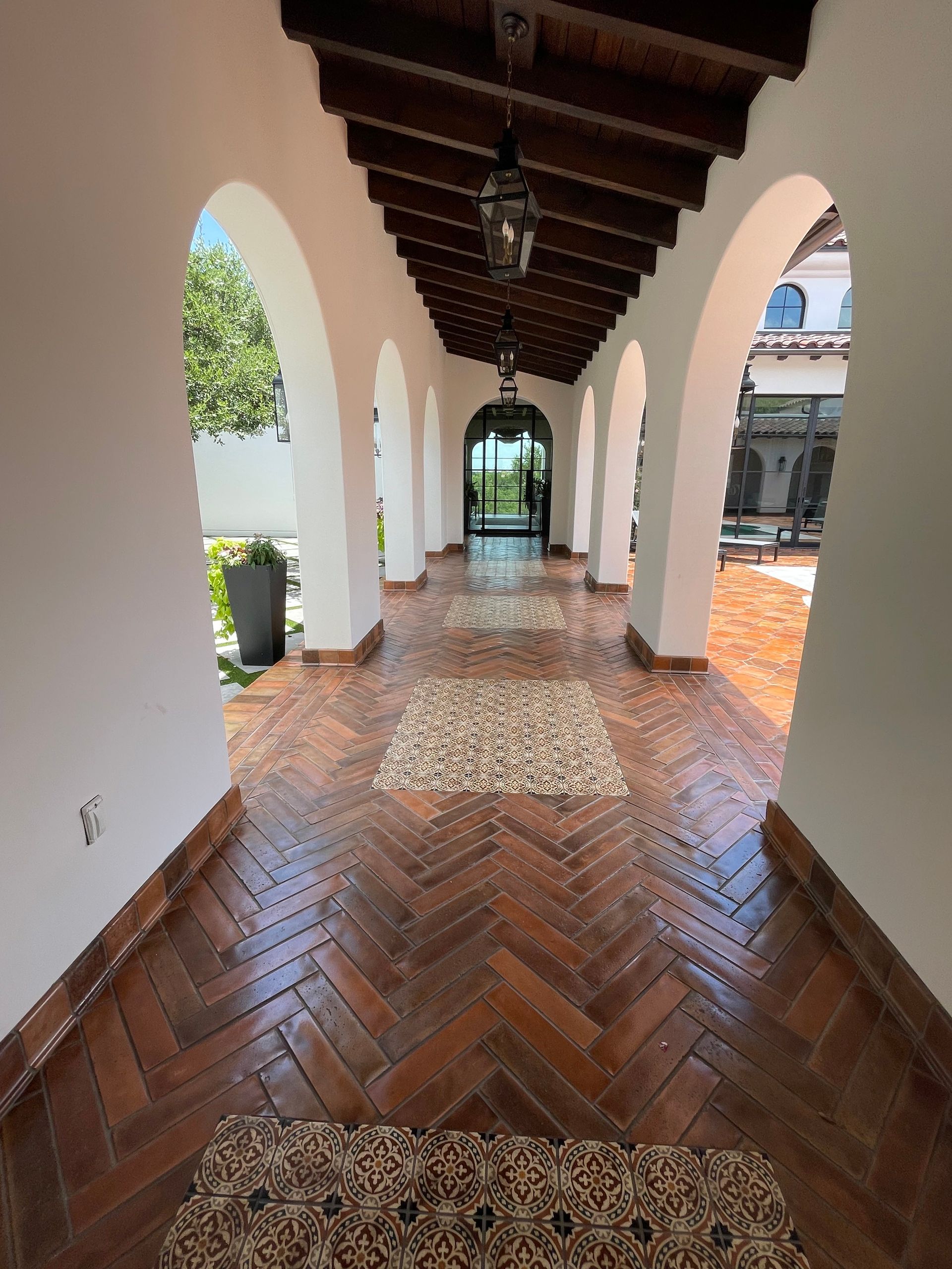 A long hallway with arches and a wooden floor