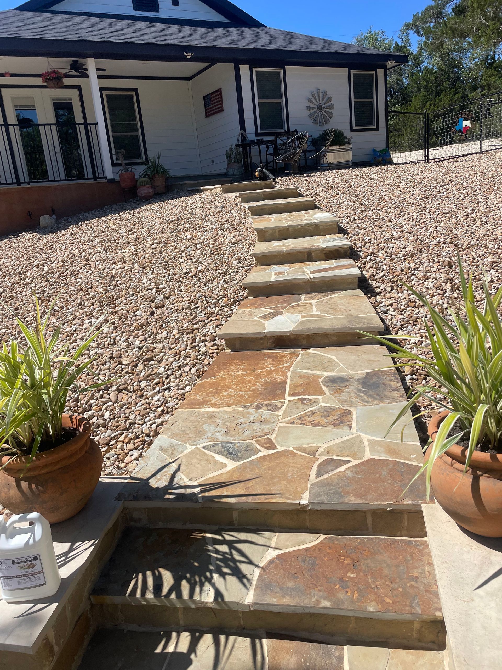 A stone walkway leading to a white house