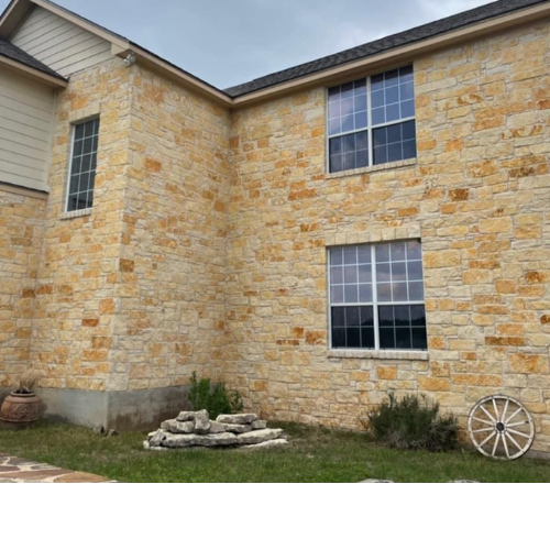 A large brick house with a wagon wheel in front of it