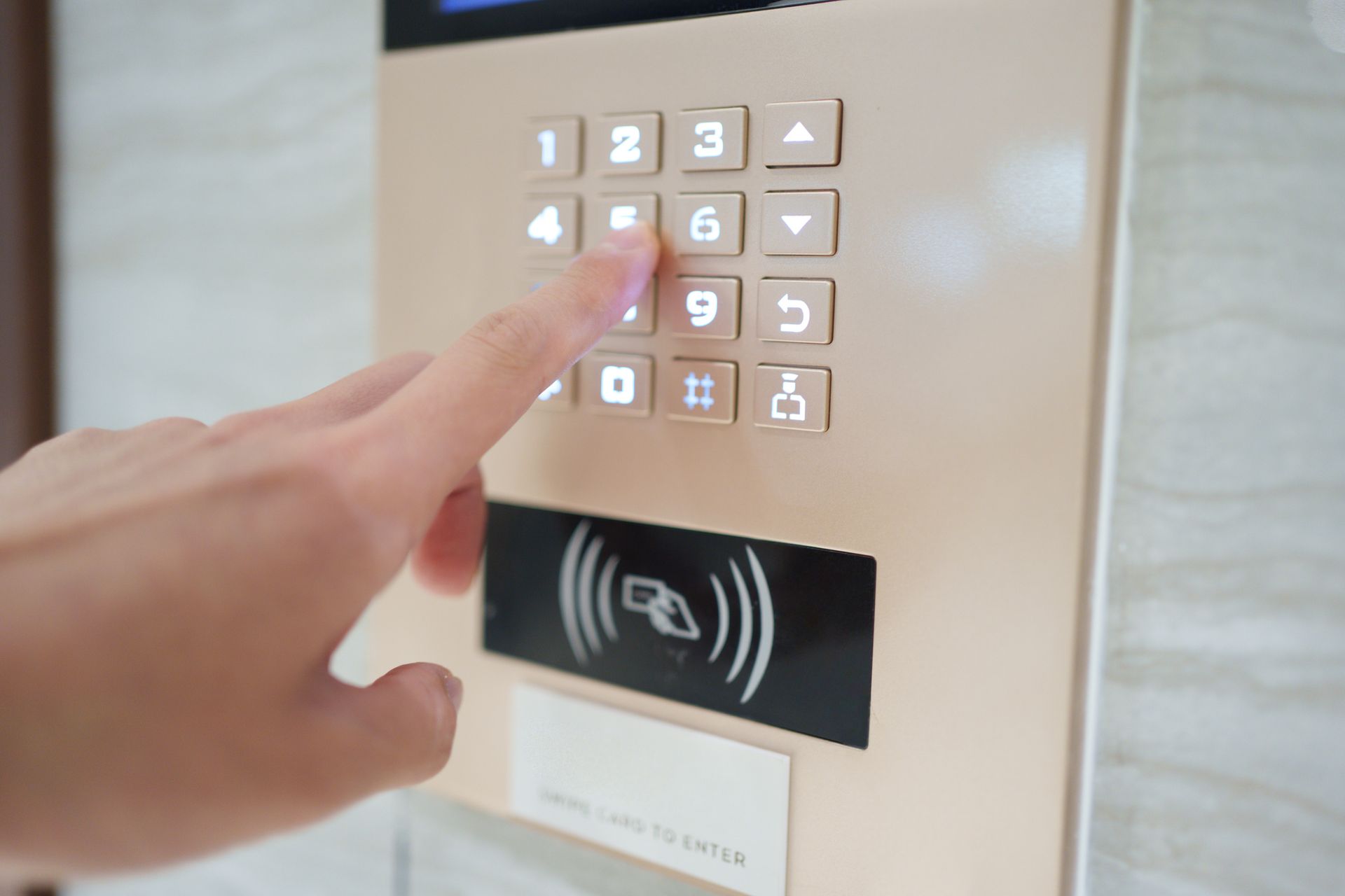 Person pressing a button on a keypad with card reader below. Person pressing a button on a keypad with card reader below.