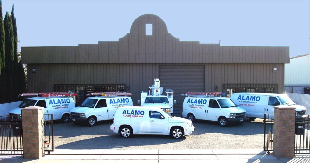 White service vehicles parked in front of a building with the business name