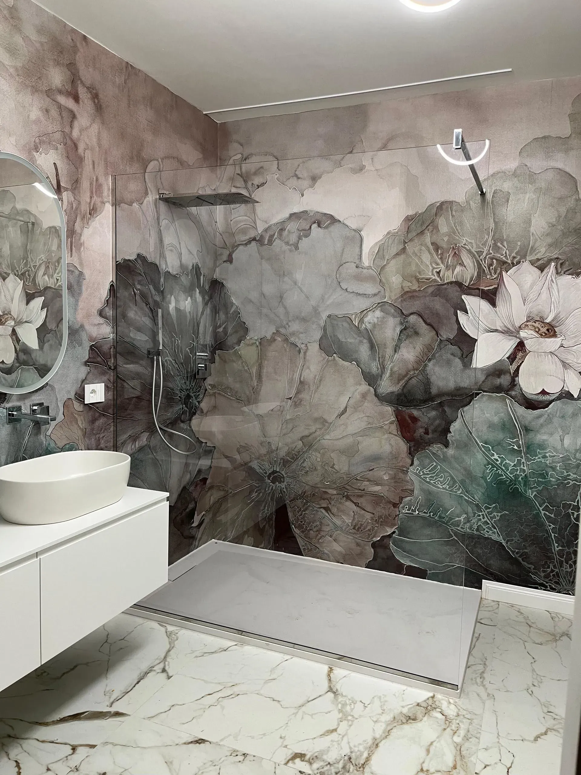 Bagno moderno con pareti decorate con murales floreali, pavimento in marmo, mobile lavabo bianco e ampia zona doccia.