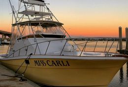 A yellow boat with the name miss carli on it