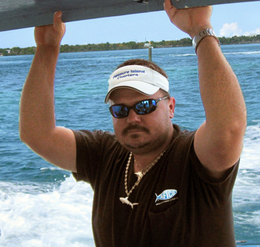 A man wearing a hat that says treasure island fishing
