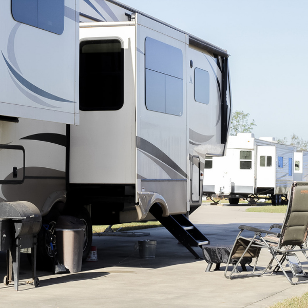 A row of rvs are parked in a parking lot