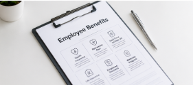 Clipboard with an employee benefits checklist on a white desk, with a pen beside it