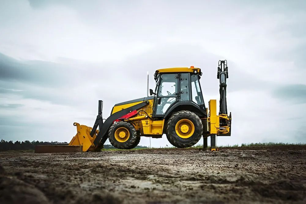 A Yellow and Black Tractor Is Parked in A Dirt Field in Rockhampton