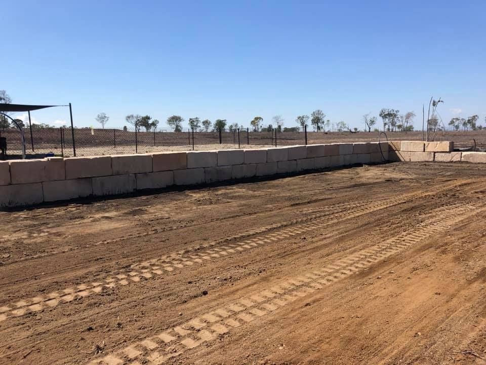 Dirt Lot With Tyre Tracks Enclosed by Stones