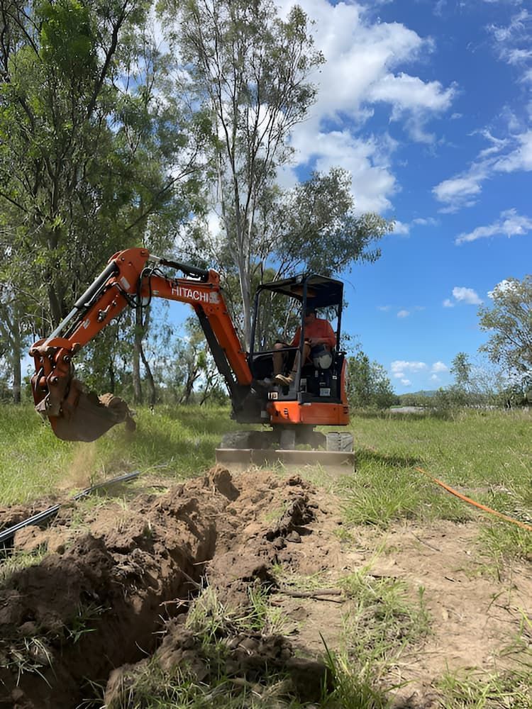 A Small Excavator Is Digging A Hole In A Field