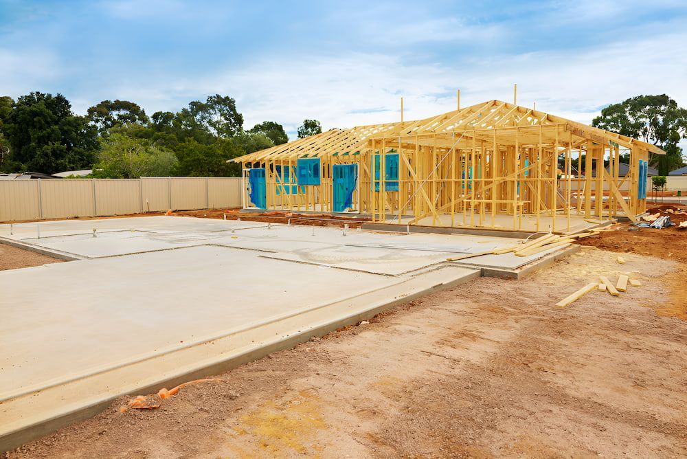 A House Is Being Built On A Dirt Lot With A Wooden Frame — Jeff Thompson Excavator Hire Pty Ltd In Pink Lily, QLD