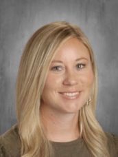 A woman with long blonde hair is smiling for a picture.