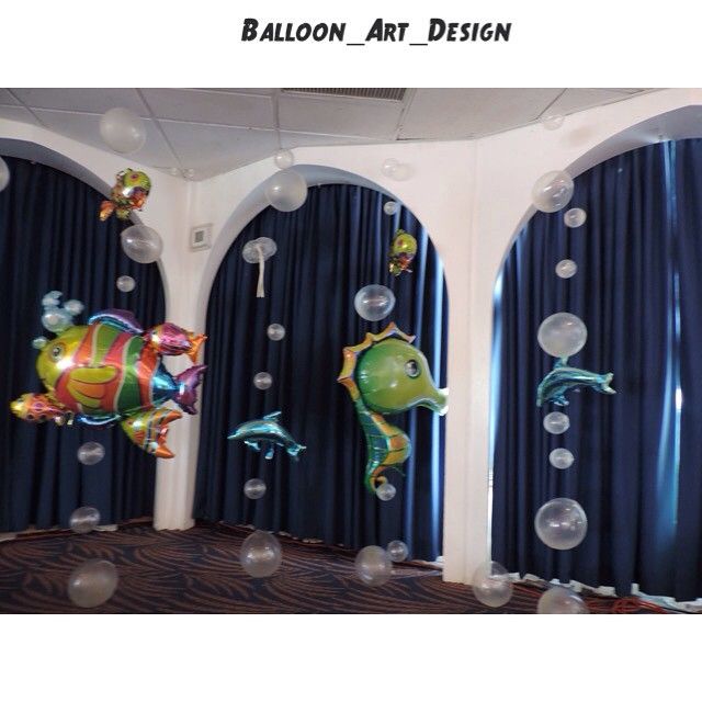 Under-the-sea themed balloon decorations with foil animal balloons and clear bubbles hanging in an arched room.