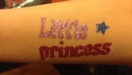 A temporary glitter tattoo on skin that reads 