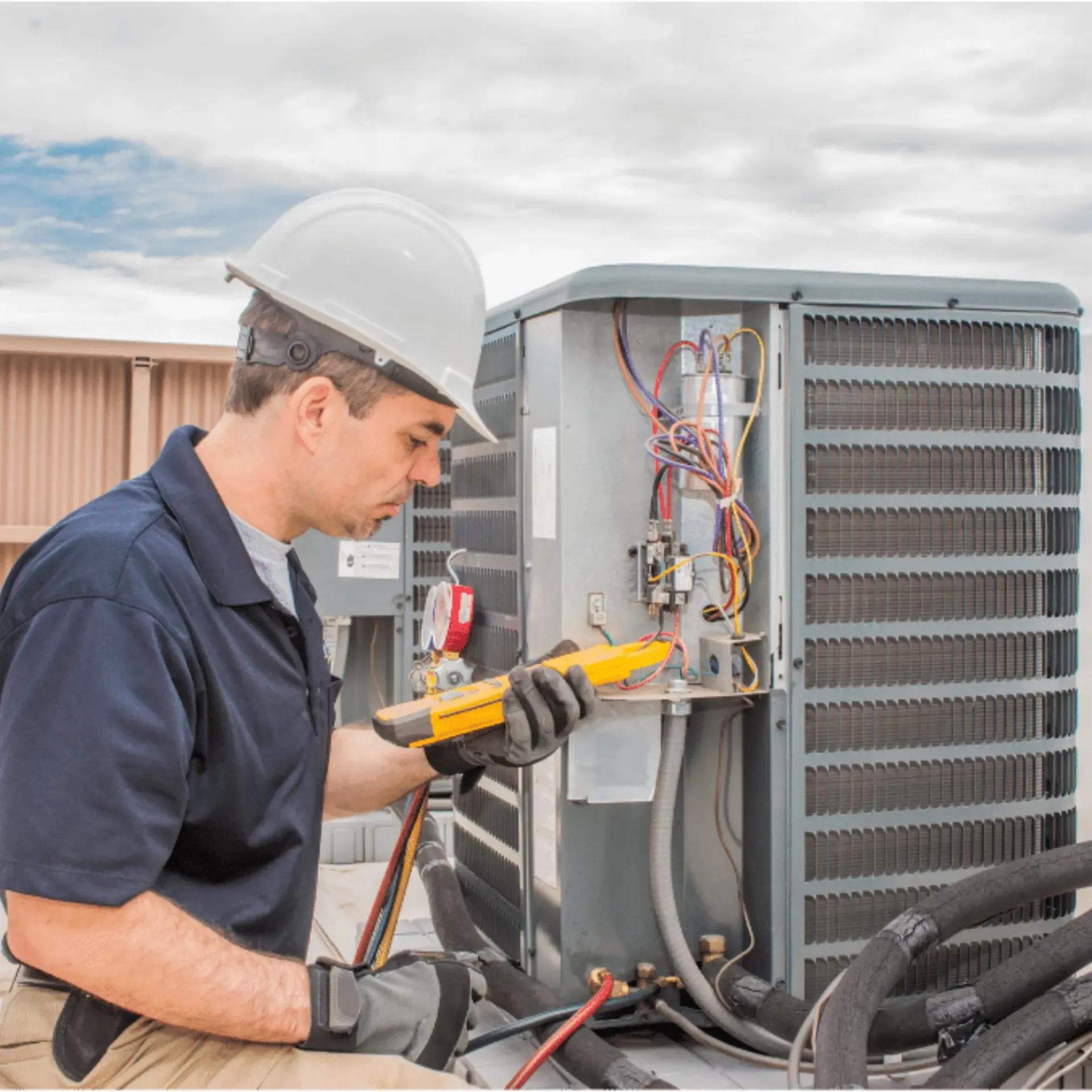 Comfort Air Solution LLC - A man wearing a hard hat is working on an air conditioner.