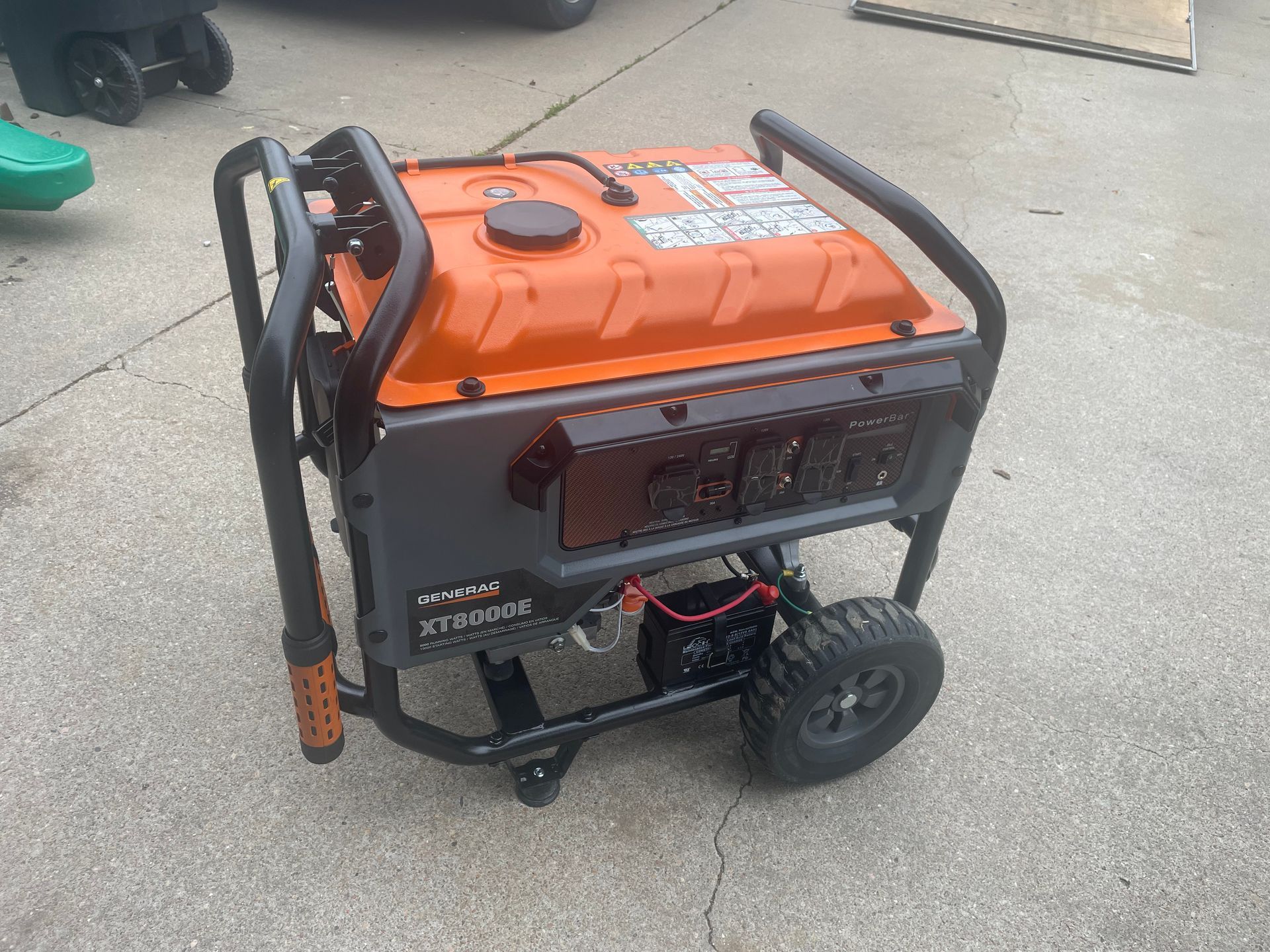 a red portable generator is sitting on a sidewalk .