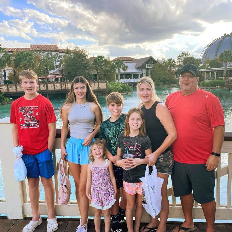 The Schluckebier Family are posing for a picture on a dock.
