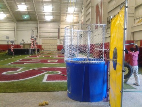 a man is standing next to a blue water bucket in a gym .