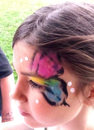 a young girl with a butterfly painted on her face .