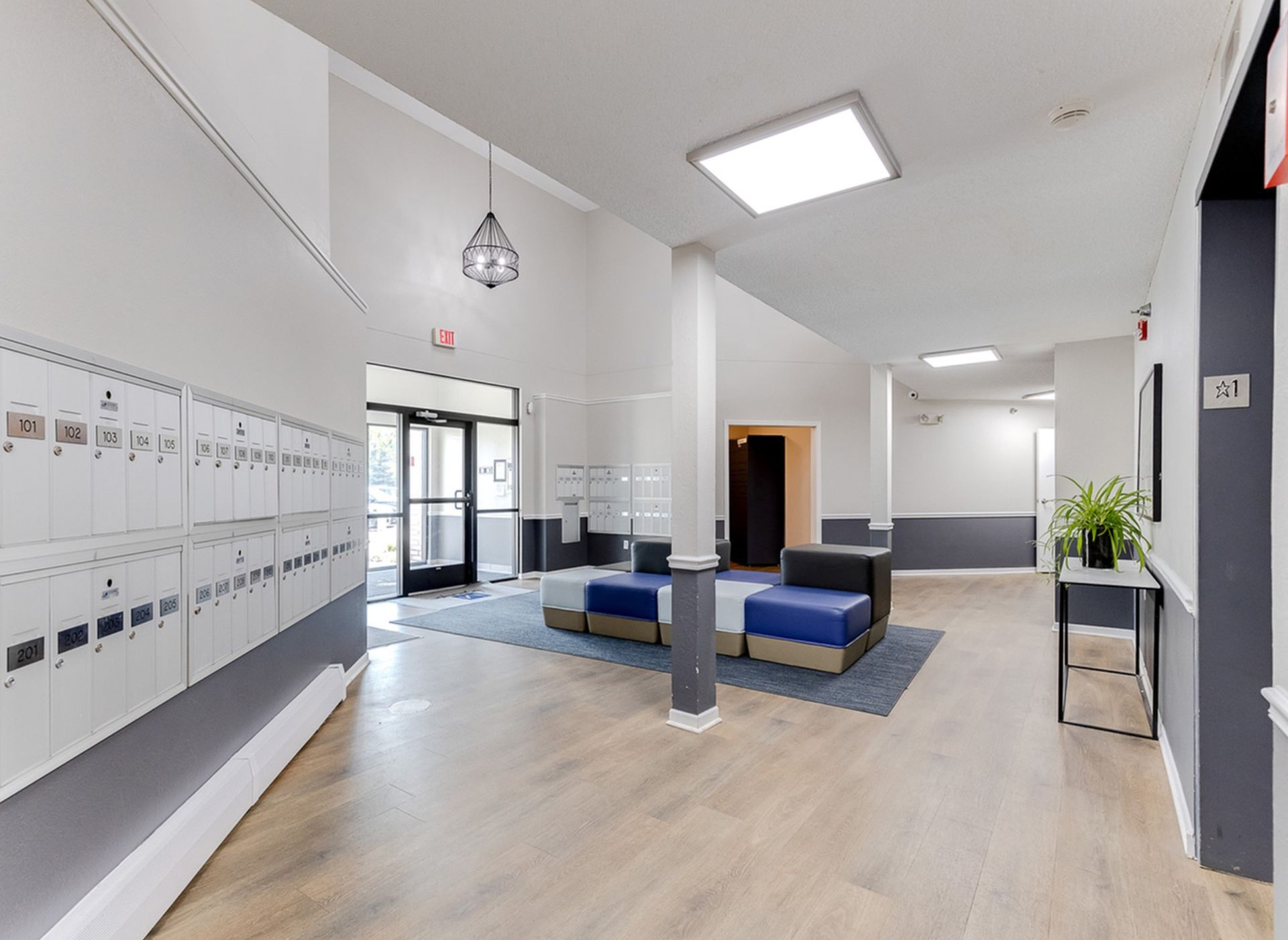 Lobby area with wall of mailboxes, seating, and entrance doors.