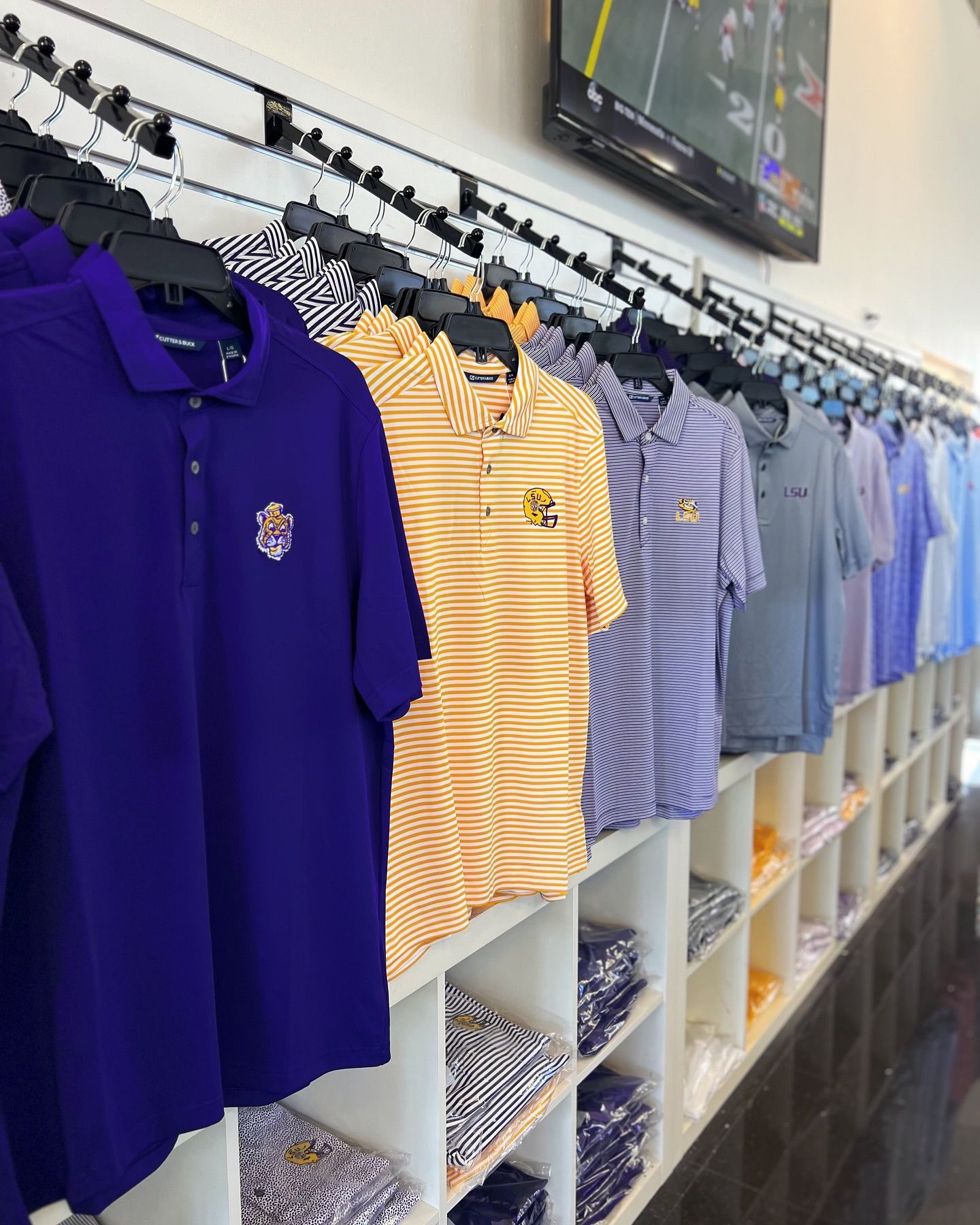 A bunch of shirts are hanging on a rack in a store
