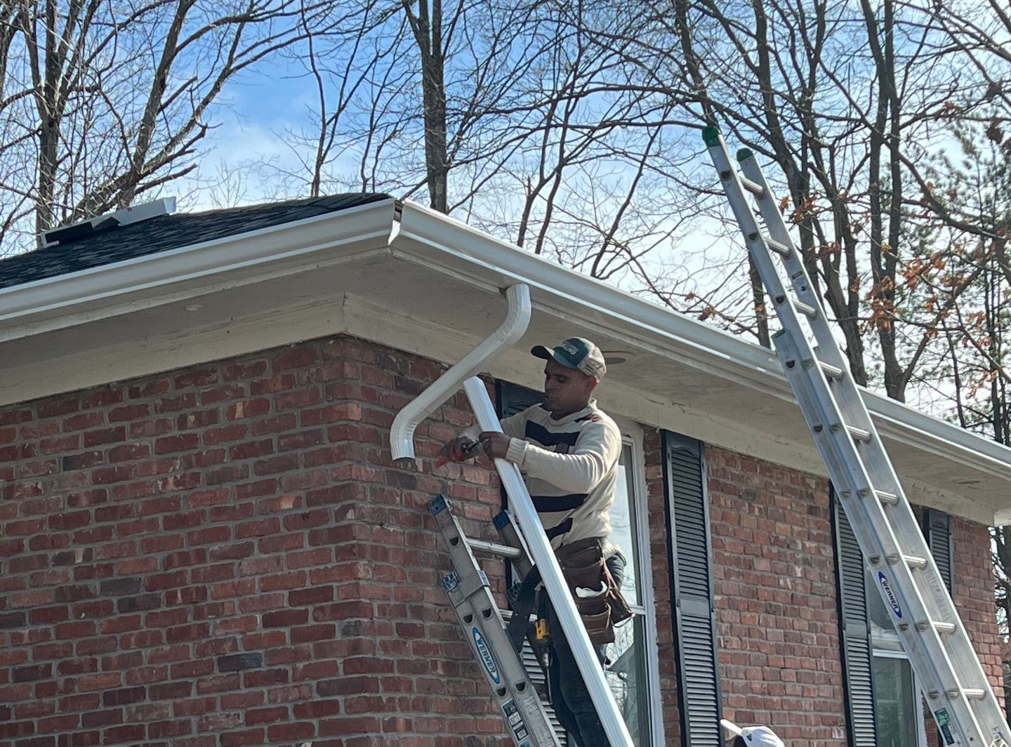 Contractor installing shingles on roof.