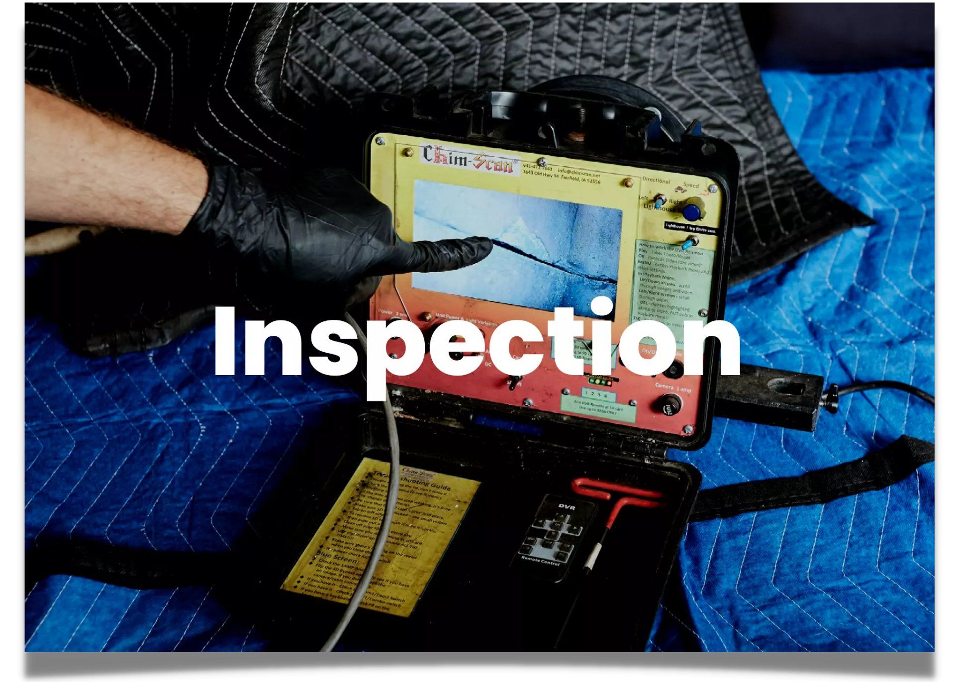 Chimney inspector pointing at a damaged flue liner being displayed on a chim-scan device.