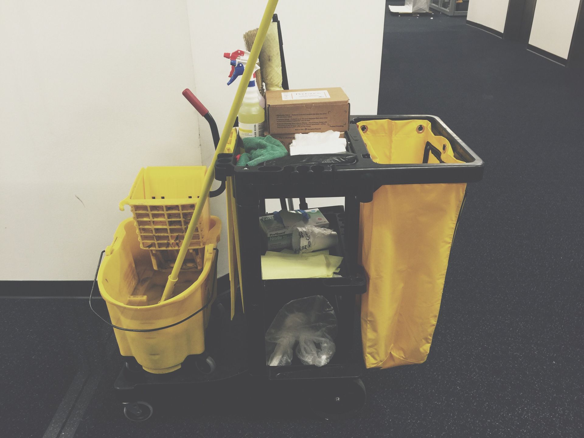 cleaning services office cleaning A cleaning cart with a mop and bucket on it