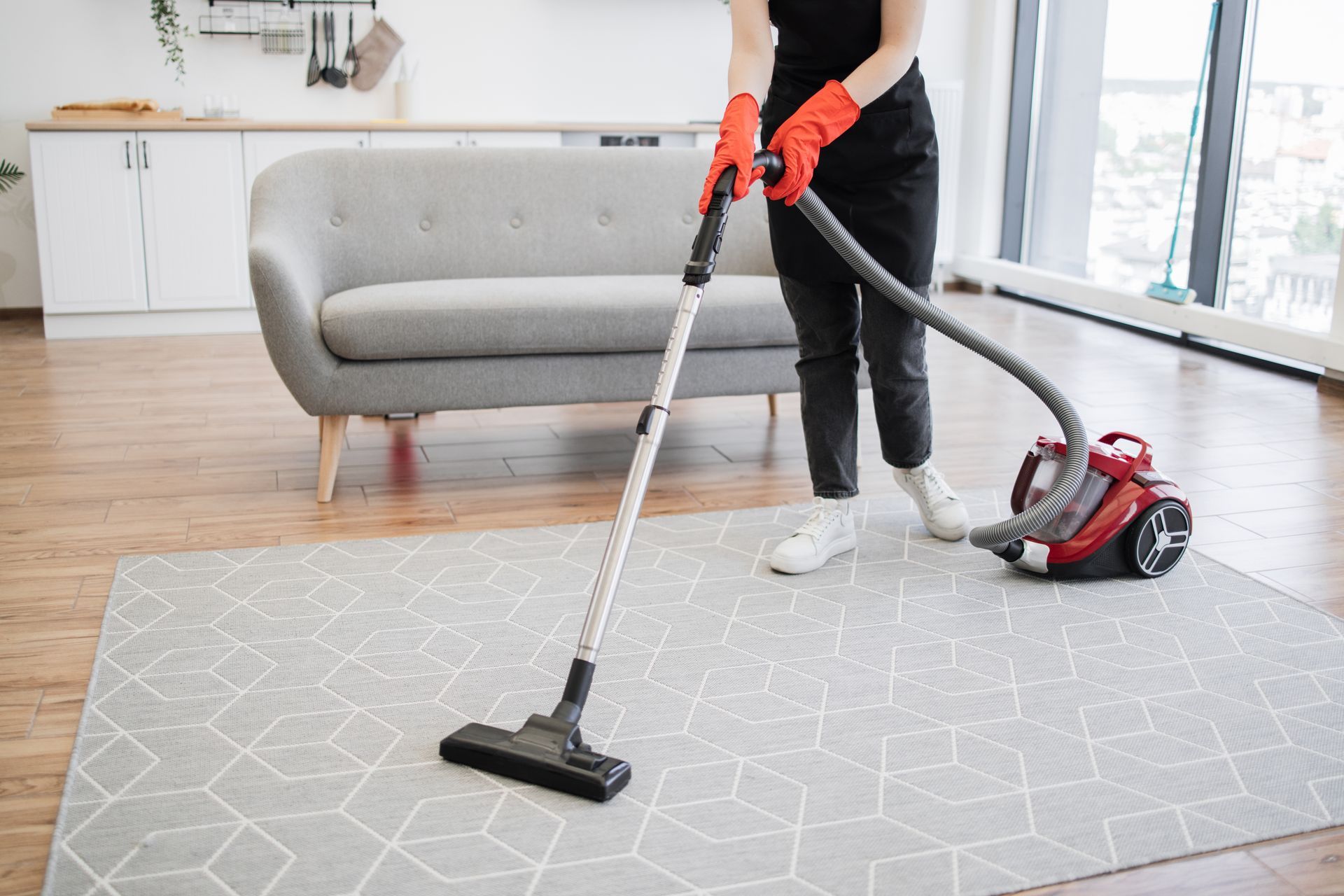 A woman is using a vacuum cleaner to clean a rug in a living room best rug cleaning companies.