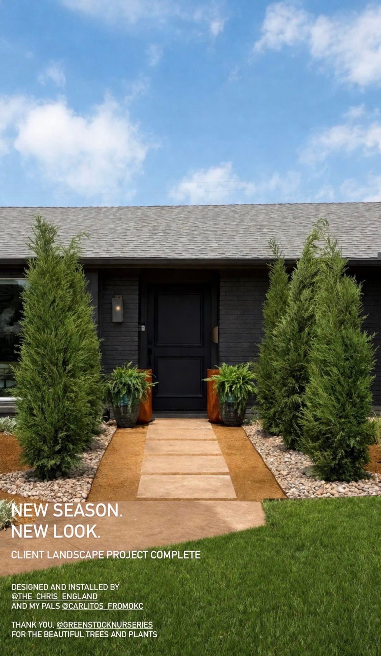 Modern house front yard with stone path, black front door, and manicured green lawn under a blue sky
