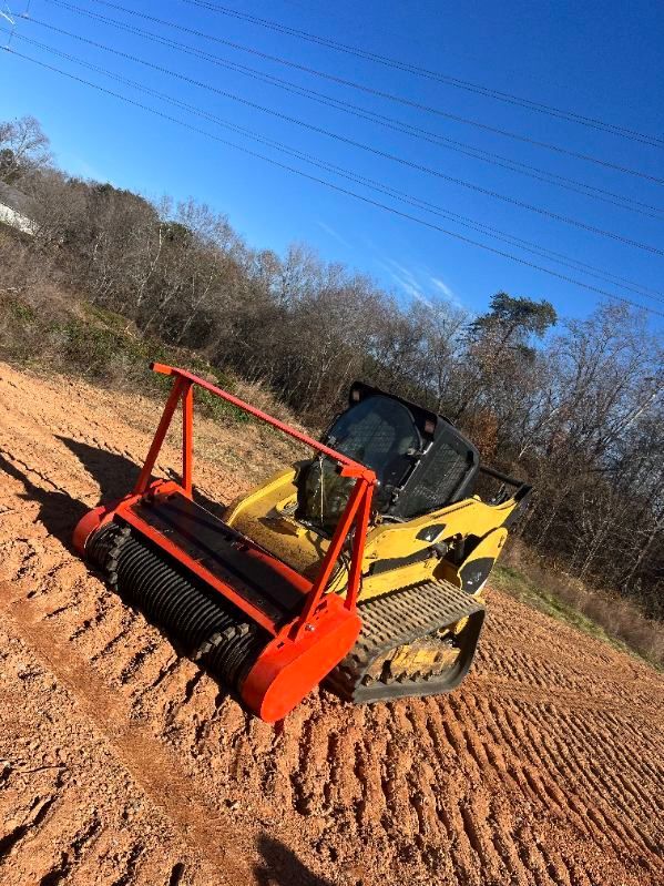 A yellow bulldozer is driving down a dirt road.