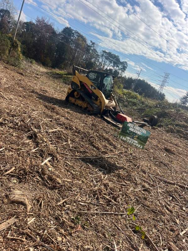 A bulldozer is sitting on top of a pile of wood chips in a field.