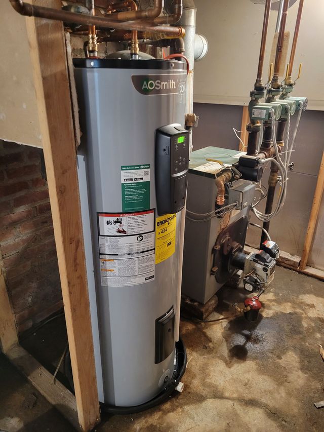 Water heater and plumbing equipment in a utility closet with a wet floor